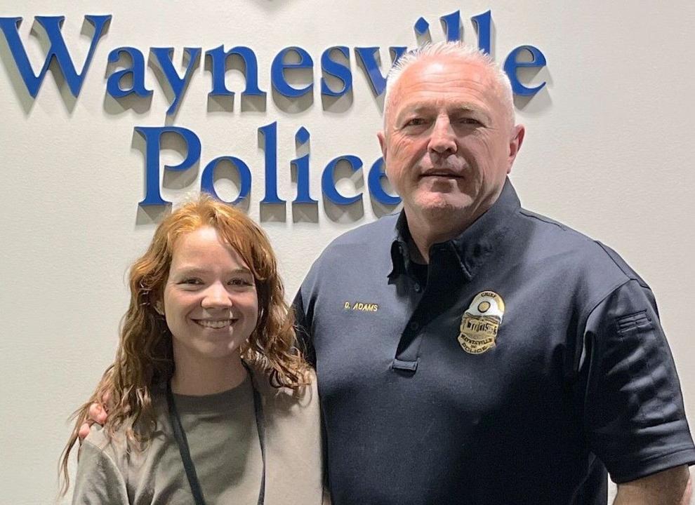 A police officer, social worker, and criminal justice professor stand in front of the Sylva Police Department